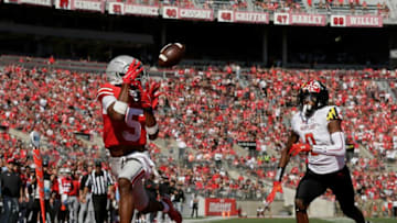 Ohio State Buckeyes wide receiver Garrett Wilson (5) catches a pass from Ohio State Buckeyes quarterback C.J. Stroud (7) and would run for a touchdown with Maryland Terrapins linebacker Terrence Lewis (0) trailing during the second half of Saturday's NCAA Division I football game at Ohio Stadium in Columbus on October 9, 2021.Osu21mary Bjp 1419
