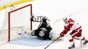 Apr 9, 2014; Pittsburgh, PA, USA; Pittsburgh Penguins goalie Marc-Andre Fleury (29) makes an acrobatic save against Detroit Red Wings right wing Daniel Alfredsson (11) during the shootout at the CONSOL Energy Center. The Penguins won 4-3 in a shootout. Mandatory Credit: Charles LeClaire-USA TODAY Sports