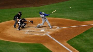 DENVER, CO - APRIL 7: David Freese #25 of the Los Angeles Dodgers hits an RBI double as catcher Chris Iannetta #22 of the Colorado Rockies and home plate umpire Bill Welke look on during the third inning at Coors Field on April 7, 2019 in Denver, Colorado. (Photo by Justin Edmonds/Getty Images)