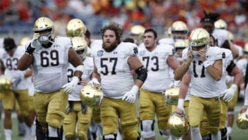 ORLANDO, FL - DECEMBER 28: Notre Dame Fighting Irish players head to the locker room after warming up prior to the Camping World Bowl against the Iowa State Cyclones at Camping World Stadium on December 28, 2019 in Orlando, Florida. Notre Dame defeated Iowa State 33-9. (Photo by Joe Robbins/Getty Images)