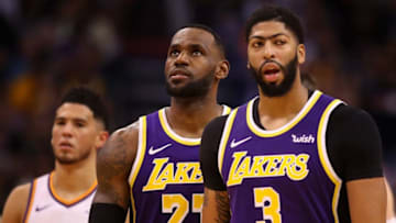 PHOENIX, ARIZONA - NOVEMBER 12: LeBron James #23 of the Los Angeles Lakers stands between Devin Booker #1 of the Phoenix Suns and Anthony Davis #3 during the second half of the NBA game at Talking Stick Resort Arena on November 12, 2019 in Phoenix, Arizona. The Lakers defeated the Suns 123-115. NOTE TO USER: User expressly acknowledges and agrees that, by downloading and/or using this photograph, user is consenting to the terms and conditions of the Getty Images License Agreement (Photo by Christian Petersen/Getty Images)