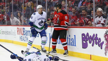 Dec 6, 2016; Newark, NJ, USA; Vancouver Canucks defenseman Philip Larsen (63) lies on the ice after being hit by New Jersey Devils left wing Taylor Hall (9) during the second period at Prudential Center. Mandatory Credit: Ed Mulholland-USA TODAY Sports