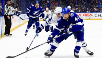 TAMPA, FLORIDA - APRIL 04: Jan Rutta #44 of the Tampa Bay Lightning and Ilya Mikheyev #65 of the Toronto Maple Leafs fight for the puck in the first period during a game at Amalie Arena on April 04, 2022 in Tampa, Florida. (Photo by Mike Ehrmann/Getty Images)