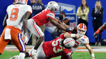 GLENDALE, ARIZONA - DECEMBER 28: Trevor Lawrence #16 of the Clemson Tigers is hit by Baron Browning #5 and Davon Hamilton #53 of the Ohio State Buckeyes in the second half during the College Football Playoff Semifinal at the PlayStation Fiesta Bowl at State Farm Stadium on December 28, 2019 in Glendale, Arizona. (Photo by Norm Hall/Getty Images)