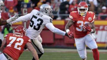 Jan 3, 2016; Kansas City, MO, USA; Kansas City Chiefs running back Spencer Ware (32) runs the ball as Oakland Raiders outside linebacker Malcolm Smith (53) defends during the first half at Arrowhead Stadium. Mandatory Credit: Denny Medley-USA TODAY Sports
