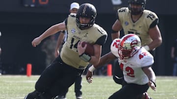 NASHVILLE, TN - NOVEMBER 04: Quarterback Kyle Shurmur #14 of the Vanderbilt Commodores rushes past Derik Overstreet #42 of the Western Kentucky University Hilltoppers during the second half at Vanderbilt Stadium on November 4, 2017 in Nashville, Tennessee. (Photo by Frederick Breedon/Getty Images)