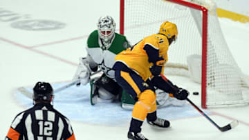 Feb 24, 2022; Nashville, Tennessee, USA; Nashville Predators center Mikael Granlund (64) scores the game winning goal past Dallas Stars goaltender Jake Oettinger (29) in the shootout at Bridgestone Arena. Mandatory Credit: Christopher Hanewinckel-USA TODAY Sports