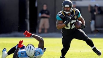 Dec 22, 2013; Jacksonville, FL, USA; Jacksonville Jaguars running back Maurice Jones-Drew (32) runs the ball past Tennessee Titans safety Bernard Pollard (31) during the game at EverBank Field. Mandatory Credit: Melina Vastola-USA TODAY Sports