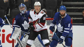 TORONTO, ON - FEBRUARY 11: Christian Dvorak #18 of the Arizona Coyotes looks for a puck to tip between Jack Campbell #36 and Jake Muzzin #8 of the Toronto Maple Leafs during an NHL game at Scotiabank Arena on February 11, 2020 in Toronto, Ontario, Canada. (Photo by Claus Andersen/Getty Images)