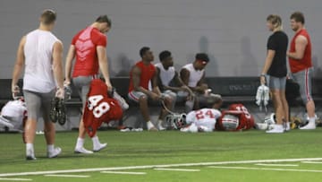 Ohio State quarterback Quinn Ewers (second from right) stops to talk with teammates as he heads into the locker room Monday.Quinn Ewers