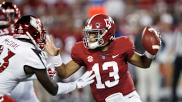 ORLANDO, FL - SEPTEMBER 01: Tua Tagovailoa #13 of the Alabama Crimson Tide fends off a tackler while looking to pass in the first quarter of the game against the Louisville Cardinals at Camping World Stadium on September 1, 2018 in Orlando, Florida. (Photo by Joe Robbins/Getty Images)