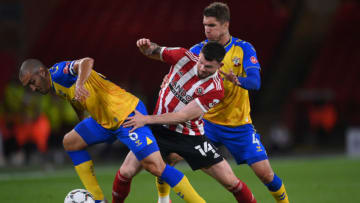 SHEFFIELD, ENGLAND - SEPTEMBER 21: Oliver Burke of Sheffield United is tackled by Oriol Romeu of Southampton (L) and Lyanco of Southampton (R) during the Carabao Cup Third Round match between Sheffield United and Southampton at Bramall Lane on September 21, 2021 in Sheffield, England. (Photo by Laurence Griffiths/Getty Images)