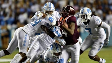 CHAPEL HILL, NC - OCTOBER 13: Trey Morrison #27, J.K. Britt #29 and Cole Holcomb #36 of the North Carolina Tar Heels tackle Damon Hazelton #14 of the Virginia Tech Hokies during their game at Kenan Stadium on October 13, 2018 in Chapel Hill, North Carolina. Virginia Tech won 22-19. (Photo by Grant Halverson/Getty Images)