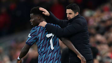 Arsenal's Spanish manager Mikel Arteta (R) speaks witj Arsenal's English midfielder Bukayo Saka (L) during the English League Cup semi-final first leg football match between Liverpool and Arsenal at Anfield in Liverpool, north west England on January 13, 2022. - - RESTRICTED TO EDITORIAL USE. No use with unauthorized audio, video, data, fixture lists, club/league logos or 'live' services. Online in-match use limited to 120 images. An additional 40 images may be used in extra time. No video emulation. Social media in-match use limited to 120 images. An additional 40 images may be used in extra time. No use in betting publications, games or single club/league/player publications. (Photo by Paul ELLIS / AFP) / RESTRICTED TO EDITORIAL USE. No use with unauthorized audio, video, data, fixture lists, club/league logos or 'live' services. Online in-match use limited to 120 images. An additional 40 images may be used in extra time. No video emulation. Social media in-match use limited to 120 images. An additional 40 images may be used in extra time. No use in betting publications, games or single club/league/player publications. / RESTRICTED TO EDITORIAL USE. No use with unauthorized audio, video, data, fixture lists, club/league logos or 'live' services. Online in-match use limited to 120 images. An additional 40 images may be used in extra time. No video emulation. Social media in-match use limited to 120 images. An additional 40 images may be used in extra time. No use in betting publications, games or single club/league/player publications. (Photo by PAUL ELLIS/AFP via Getty Images)