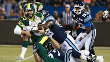 TORONTO, ON - OCTOBER 4: Mike Reilly #13 of the Edmonton Eskimos is tackled by Delano Johnson #93 of the Toronto Argonauts during their game at Rogers Centre on October 4, 2014 in Toronto, Canada. (Photo by Dave Sandford/Getty Images)