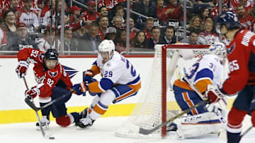 Apr 5, 2016; Washington, DC, USA; Washington Capitals center Evgeny Kuznetsov (92) passes the puck behind New York Islanders goalie Christopher Gibson (33) as Islanders center Brock Nelson (29) defends in the first period at Verizon Center. Mandatory Credit: Geoff Burke-USA TODAY Sports
