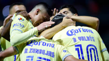 América players celebrate with Diego Valdés after his controversial goal put the Aguilas up 2-0. América clinched a Liga MX playoff spot with their win Tuesday night. (Photo by ALFREDO ESTRELLA/AFP via Getty Images)