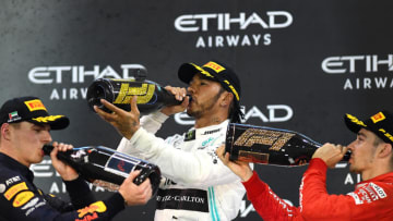 ABU DHABI, UNITED ARAB EMIRATES - DECEMBER 01: Top three finishers Lewis Hamilton of Great Britain and Mercedes GP, Max Verstappen of Netherlands and Red Bull Racing and Charles Leclerc of Monaco and Ferrari celebrate on the podium during the F1 Grand Prix of Abu Dhabi at Yas Marina Circuit on December 01, 2019 in Abu Dhabi, United Arab Emirates. (Photo by Clive Mason/Getty Images)