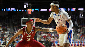 Mar 18, 2023; Des Moines, IA, USA; Kansas Jayhawks guard Dajuan Harris Jr. (right) controls the ball against Arkansas Razorbacks guard Nick Smith Jr. (left) during the first half at Wells Fargo Arena. Mandatory Credit: Jeffrey Becker-USA TODAY Sports