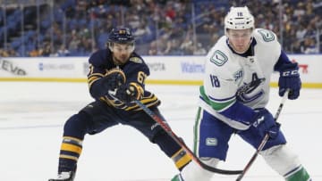 BUFFALO, NY - JANUARY 11: Michael Frolik #67 of the Buffalo Sabres skates against Jake Virtanen #18 of the Vancouver Canucks during the third period of play in the NHL hockey game between the Vancouver Canucks and Buffalo Sabres at KeyBank Center on January 11, 2020 in Buffalo, New York. (Photo by Nicholas T. LoVerde/Getty Images)