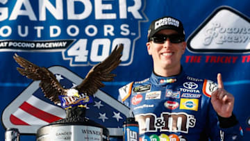 LONG POND, PA - JULY 29: Kyle Busch, driver of the #18 M&M's Caramel Toyota, poses with the trophy in Victory Lane after winning the Monster Energy NASCAR Cup Series Gander Outdoors 400 at Pocono Raceway on July 29, 2018 in Long Pond, Pennsylvania. (Photo by Jeff Zelevansky/Getty Images)