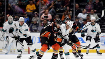 ANAHEIM, CALIFORNIA - SEPTEMBER 24: Korbinian Holzer #5 of the Anaheim Ducks and Alexander True #70 of the San Jose Sharks get tangled going after the puck during the second period in a preseason game at Honda Center on September 24, 2019 in Anaheim, California. (Photo by Harry How/Getty Images)