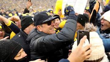 ANN ARBOR, MICHIGAN - NOVEMBER 27: Head Coach Jim Harbaugh of the Michigan Wolverines celebrates with fans after defeating the Ohio State Buckeyes at Michigan Stadium on November 27, 2021 in Ann Arbor, Michigan. (Photo by Mike Mulholland/Getty Images)