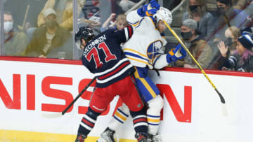 Dec 14, 2021; Winnipeg, Manitoba, CAN; Winnipeg Jets forward Evgeny Svechnikov (71) boards Buffalo Sabres forward Anders Bjork (96) during the third period at Canada Life Centre. Mandatory Credit: Terrence Lee-USA TODAY Sports