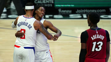 Feb 15, 2021; Los Angeles, California, USA; LA Clippers forward Marcus Morris Sr. (8) and guard Terance Mann (14) embrace at the end of the game as Miami Heat center Bam Adebayo (13) watches at Staples Center. The Clippers defeated the Heat 125-118. Mandatory Credit: Kirby Lee-USA TODAY Sports