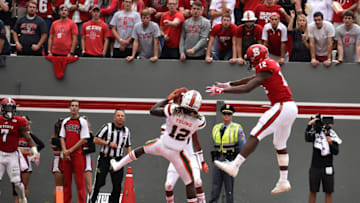 RALEIGH, NC - NOVEMBER 19: Malek Young #12 of the Miami Hurricanes intercepts a pass intended for Bra'Lon Cherry #13 of the North Carolina State Wolfpack at Carter-Finley Stadium on November 19, 2016 in Raleigh, North Carolina. Miami won 27-13. (Photo by Lance King/Getty Images)