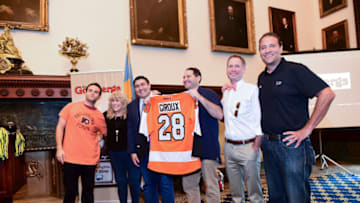 PHILADELPHIA, PA - SEPTEMBER 15: (L-R) Actor Troy Gentile, Beverly Goldberg, guest and Ike Richman, VP of Public relations at Comcast-Spector presents Producer Adam F. Goldberg with official Philadelphia Flyers shirt during an event honoring Goldberg at Philadelphia City Hall on September 15, 2017 in Philadelphia, Pennsylvania. Goldberg was honored with the Liberty Bell as the City of Philadelphia proclaims September 15th The Goldbergs Syndication Day. (Photo by Lisa Lake/Getty Images for Sony Pictures Television)