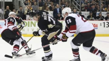 Feb 29, 2016; Pittsburgh, PA, USA; Pittsburgh Penguins center Evgeni Malkin (71) skates with the puck between Arizona Coyotes defenseman Oliver Ekman-Larsson (23) and defenseman Michael Stone (26) during the second period at the CONSOL Energy Center. Mandatory Credit: Charles LeClaire-USA TODAY Sports