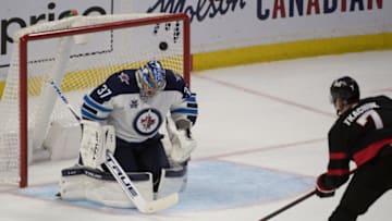 Apr 12, 2021; Ottawa, Ontario, CAN; Ottawa Senators left wing Brady Tkachuk (7) scores against Winnipeg Jets goalie Connor Hellebuyck (37) in the third period at the Canadian Tire Centre. Mandatory Credit: Marc DesRosiers-USA TODAY Sports