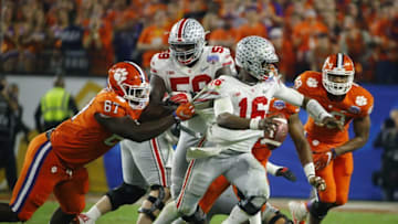 Dec 31, 2016; Phoenix, AZ, USA; Clemson Tigers defensive tackle Albert Huggins (67) grabs the jersey of Ohio State Buckeyes quarterback J.T. Barrett (16) as he scrambles during the fourth quarter during the 2016 CFP semifinal at University of Phoenix Stadium. Mandatory Credit: David Kadlubowski/The Arizona Republic via USA TODAY Sports