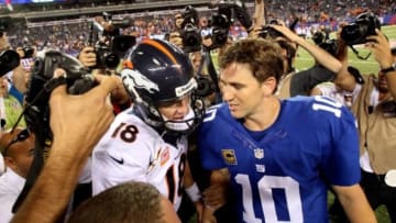 Sep 15, 2013; East Rutherford, NJ, USA; Denver Broncos quarterback Peyton Manning (18) shakes hands with New York Giants quarterback Eli Manning (10) after a game at MetLife Stadium. The Broncos defeated the Giants 41-23. Mandatory Credit: Brad Penner-USA TODAY Sports