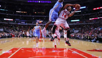 Feb 21, 2014; Chicago, IL, USA; Chicago Bulls point guard D.J. Augustin (14) is fouled by Denver Nuggets point guard Aaron Brooks (0) during the second half at the United Center. Chicago won 117-89. Mandatory Credit: Dennis Wierzbicki-USA TODAY Sports