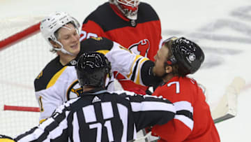 Jan 14, 2021; Newark, New Jersey, USA; Boston Bruins center Trent Frederic (11) and New Jersey Devils defenseman Matt Tennyson (7) push and shove during the second period at Prudential Center. Mandatory Credit: Ed Mulholland-USA TODAY Sports