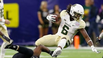 HOUSTON, TEXAS - DECEMBER 27: JaMycal Hasty #6 of the Baylor Bears is tripped up by Dare Odeyingbo #34 of the Vanderbilt Commodores during the Academy Sports + Outdoors Texas Bowl at NRG Stadium on December 27, 2018 in Houston, Texas. (Photo by Bob Levey/Getty Images)