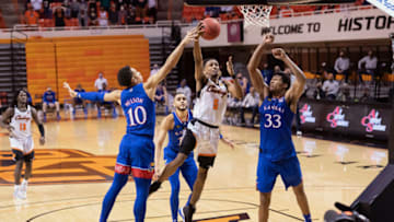 Jan 12, 2021; Stillwater, Oklahoma, USA; Oklahoma State Cowboys guard Rondel Walker (5) shoots the ball against Kansas Jayhawks forward Jalen Wilson (10) and forward David McCormack (33) during the second half at Gallagher-Iba Arena. Mandatory Credit: Rob Ferguson-USA TODAY Sports