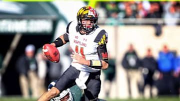 Nov 14, 2015; East Lansing, MI, USA; Maryland Terrapins quarterback Perry Hills (11) is flushed out of the pocket by Michigan State Spartans defensive lineman Malik McDowell (4) during the 2nd half of a game at Spartan Stadium. Mandatory Credit: Mike Carter-USA TODAY Sports