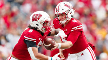 Oct 30, 2021; Madison, Wisconsin, USA; Wisconsin Badgers quarterback Graham Mertz (5) hans the football off to running back Chez Mellusi (6) during the first quarter against the Iowa Hawkeyes at Camp Randall Stadium. Mandatory Credit: Jeff Hanisch-USA TODAY Sports