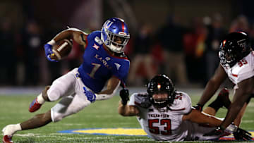 LAWRENCE, KANSAS - OCTOBER 26: Running back Pooka Williams Jr. #1 of the Kansas Jayhawks carries the ball as defensive lineman Eli Howard #53 and defensive lineman Jaylon Hutchings #95 of the Texas Tech Red Raiders defend during the game at Memorial Stadium on October 26, 2019 in Lawrence, Kansas. (Photo by Jamie Squire/Getty Images)