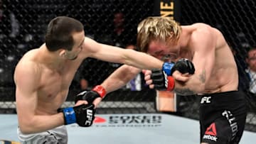 LAS VEGAS, NEVADA - JANUARY 18: (L-R) Askar Askarov of Russia and Tim Elliot trade punches in their flyweight fight during the UFC 246 event at T-Mobile Arena on January 18, 2020 in Las Vegas, Nevada. (Photo by Jeff Bottari/Zuffa LLC via Getty Images)