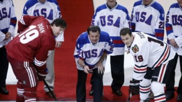 Feb 7, 2014; Glendale, AZ, USA; 1980 USA Olympic Gold Medal captain Mike Eruzione drops the puck between Phoenix Coyotes right wing Shane Doan (19) and Chicago Blackhawks center Jonathan Toews (19) at Jobing.com Arena. Mandatory Credit: Rick Scuteri-USA TODAY Sports