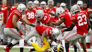Nov 29, 2014; Columbus, OH, USA; Ohio State Buckeyes defenders swarm to make the tackle of Michigan Wolverines quarterback Devin Gardner (98) during fourth quarter action at Ohio Stadium. Ohio State won the game 42-28 over the Michigan Wolverines. Mandatory Credit: Joe Maiorana-USA TODAY Sports