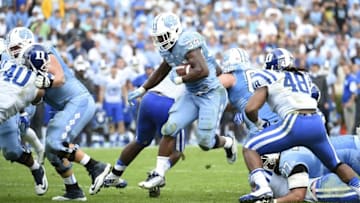 Nov 7, 2015; Chapel Hill, NC, USA; North Carolina Tar Heels running back Elijah Hood (34) runs as Duke Blue Devils linebacker Dwayne Norman (40) and defensive end Deion Williams (48) defend in the second quarter at Kenan Memorial Stadium. Mandatory Credit: Bob Donnan-USA TODAY Sports