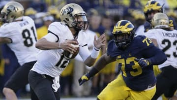 ANN ARBOR, MI - SEPTEMBER 17: Quarterback Steven Montez #12 of the Colorado Buffaloes is pursued by Maurice Hurst #73 of the Michigan Wolverine during the second half at Michigan Stadium on September 17, 2016 in Ann Arbor, Michigan. Michigan defeated Colorado 45-28. (Photo by Duane Burleson/Getty Images)