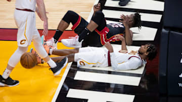 Apr 3, 2021; Miami, Florida, USA; Miami Heat forward Jimmy Butler (22) and Cleveland Cavaliers guard Darius Garland (10) react to an offensive charge foul call on Butler during the third quarter of a game at American Airlines Arena. Mandatory Credit: Mary Holt-USA TODAY Sports