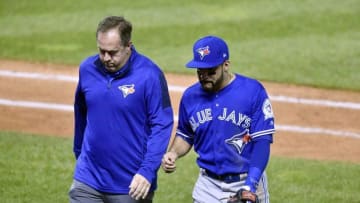 Oct 14, 2016; Cleveland, OH, USA; Toronto Blue Jays second baseman Devon Travis walks off the field with a trainer in the 5th inning against the Cleveland Indians in game one of the 2016 ALCS playoff baseball series at Progressive Field. Mandatory Credit: David Richard-USA TODAY Sports
