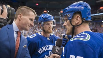 VANCOUVER, BC - OCTOBER 5: Daniel Sedin #22 and brother Henrik Sedin #33 of the Vancouver Canucks take to tv reporter Dan Murphy prior to their final home game against the Arizona Coyotes in NHL action on April, 5, 2018 at Rogers Arena in Vancouver, British Columbia, Canada. (Photo by Rich Lam/Getty Images)